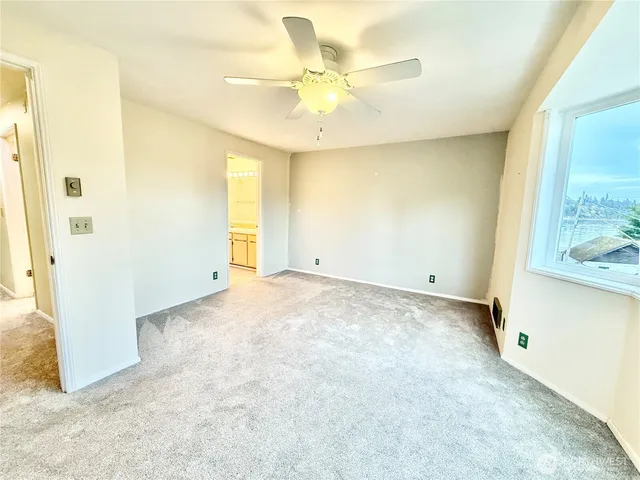 an empty room with a ceiling fan and a bathroom