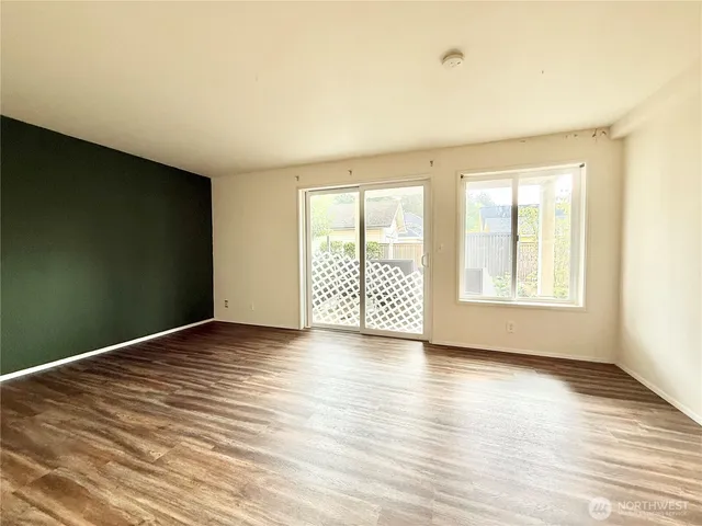 a view of empty room with wooden floor