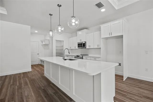 a kitchen with white cabinets sink and stainless steel appliances