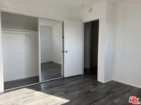 an empty room with wooden floor and closet