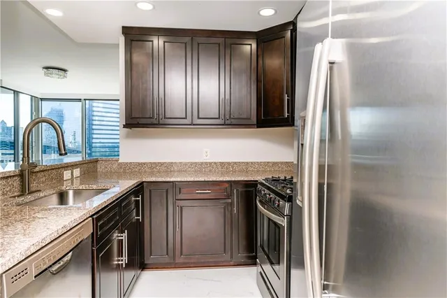 a kitchen with granite countertop stainless steel appliances and a sink