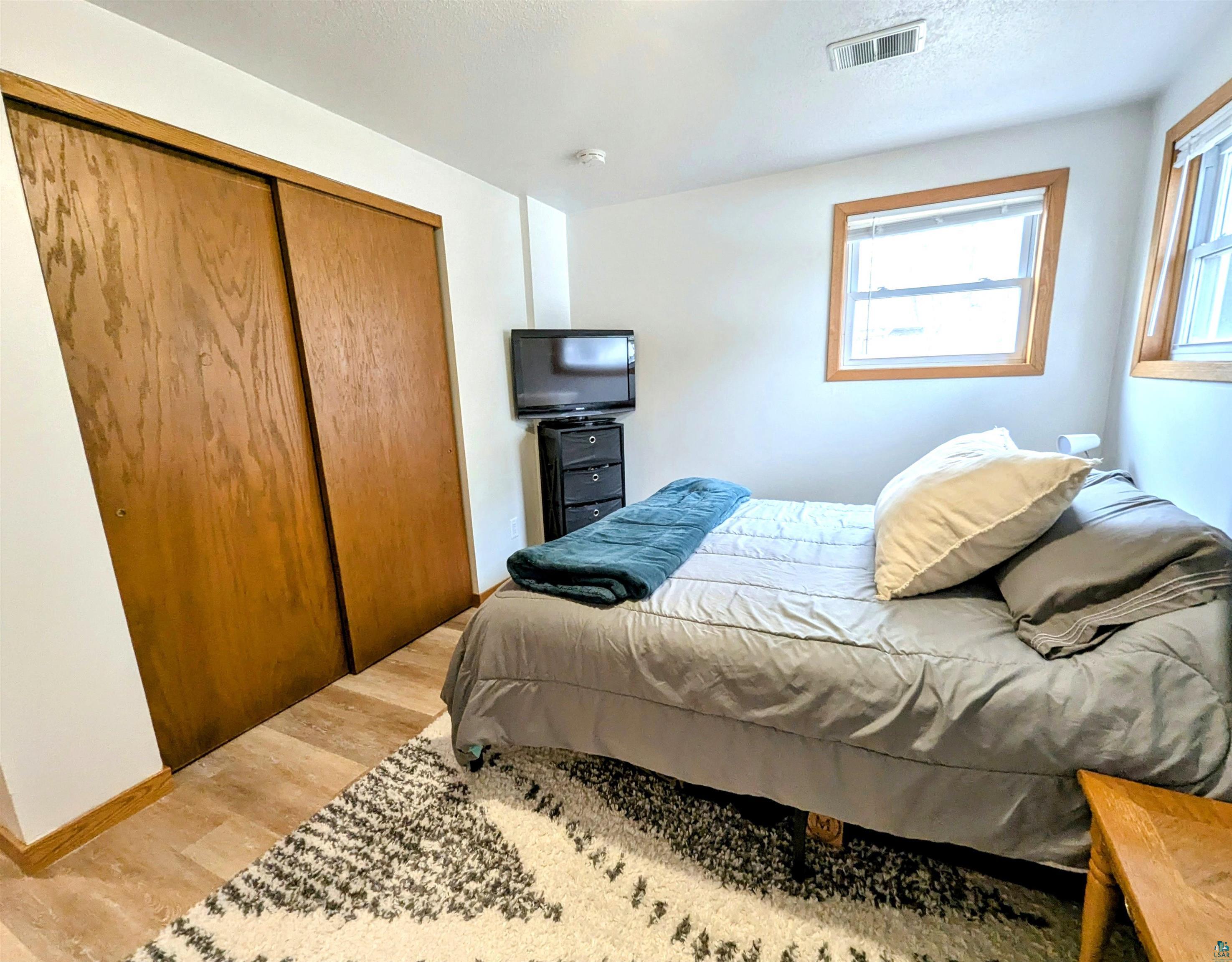 3321 Decker Road Duluth, MN 55811 - Photo 23 of 31 Bedroom featuring a closet, baseboards, visible vents, and light wood finished floors