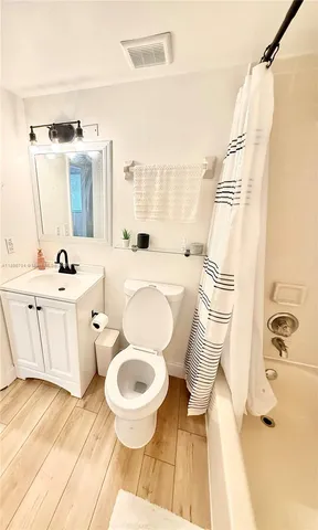 a bathroom with a sink a toilet a mirror and shower
