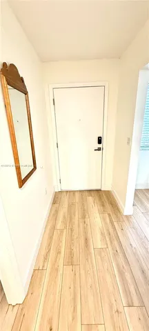 a view of a hallway with furniture and wooden floor