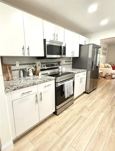 a kitchen with stainless steel appliances granite countertop a stove a sink and a microwave