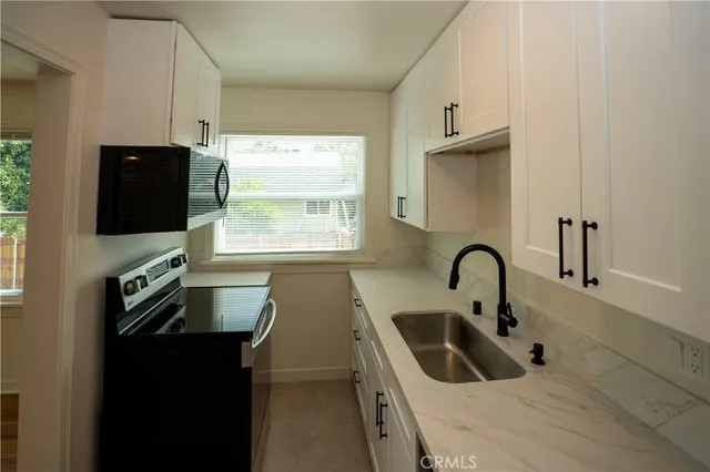 a kitchen with a sink a stove and a refrigerator