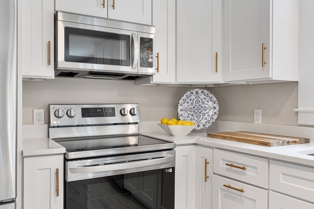 9 Springwell Road Billerica, MA 01821 - Photo 14 of 37 a kitchen with white cabinets and appliances