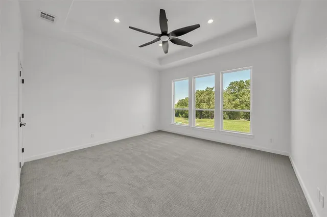 an empty room with windows and fan