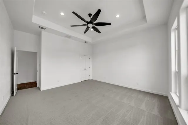 an empty room with ceiling fan and window