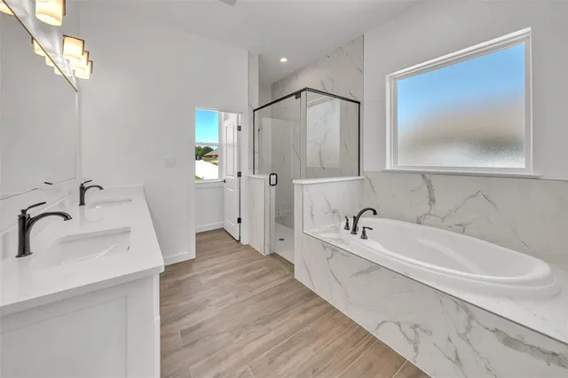 a bathroom with a tub sink and mirror
