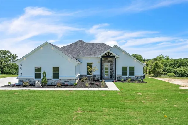 a front view of house with yard seating and green space