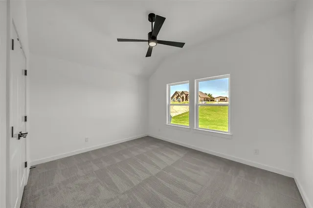 an empty room with windows and ceiling fan