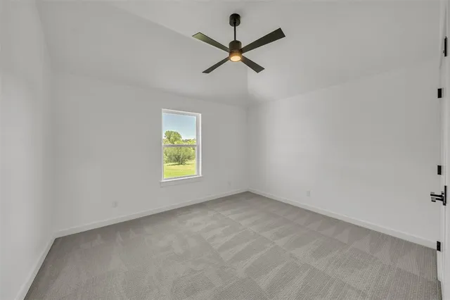 an empty room with a window and a ceiling fan