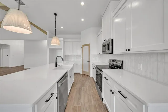 a kitchen with stainless steel appliances a sink stove and refrigerator
