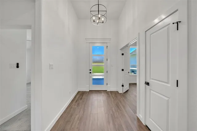 a view of a hallway with wooden floor and closet