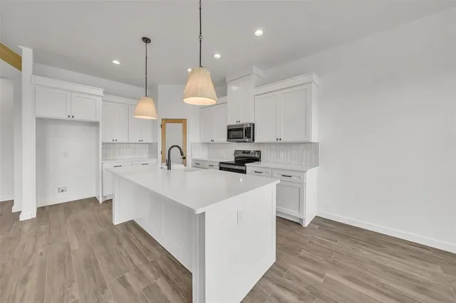 a kitchen with kitchen island a sink stainless steel appliances and cabinets