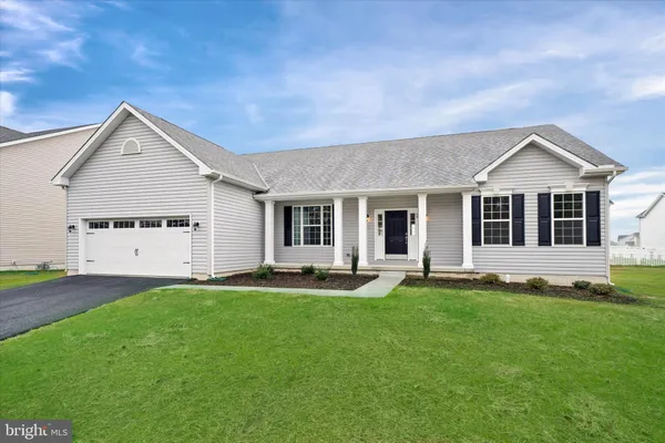 a front view of a house with a garden and yard