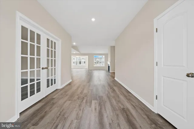a hallway with wooden floor and windows