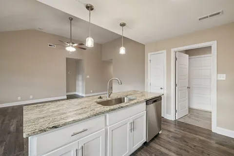 a bathroom with a granite countertop double vanity sink and a mirror