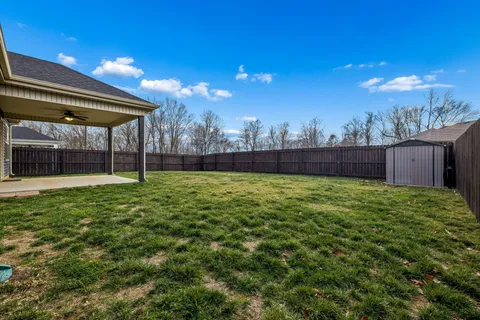 a view of an house with backyard and a garden
