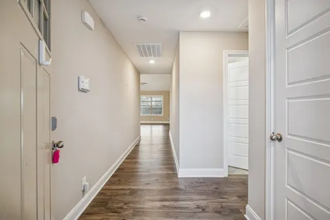 a view of a hallway with wooden floor and staircase