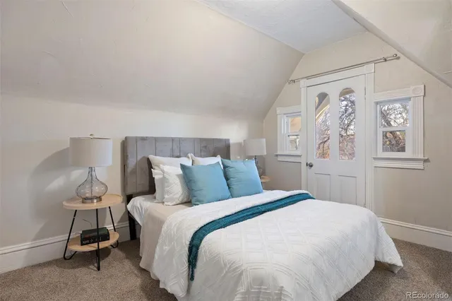 a large bed sitting in a bedroom next to a window