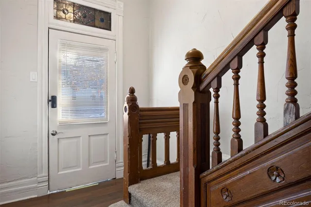 a view of a hallway with wooden floor and staircase
