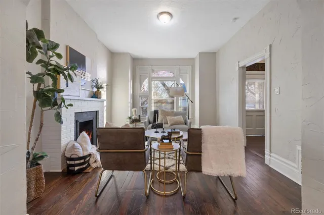 a living room with fireplace furniture and a wooden floor