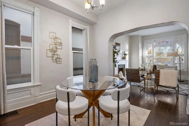 a view of a livingroom and dining room with furniture wooden floor and a chandelier