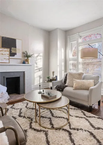 a living room with furniture a fireplace and a large window