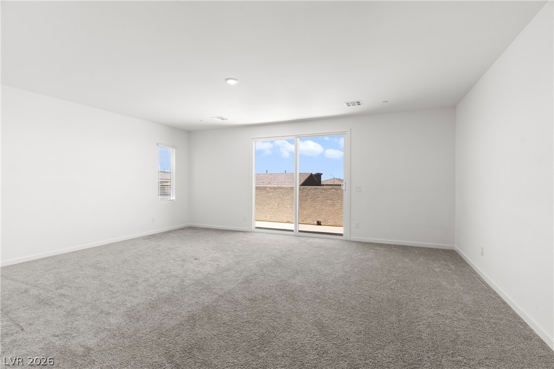 320 Isla Enclave Way Henderson, NV 89011 - Photo 24 of 49 This generous, well-lit living area features neutral carpeting and provides convenient outdoor access through sliding glass doors.