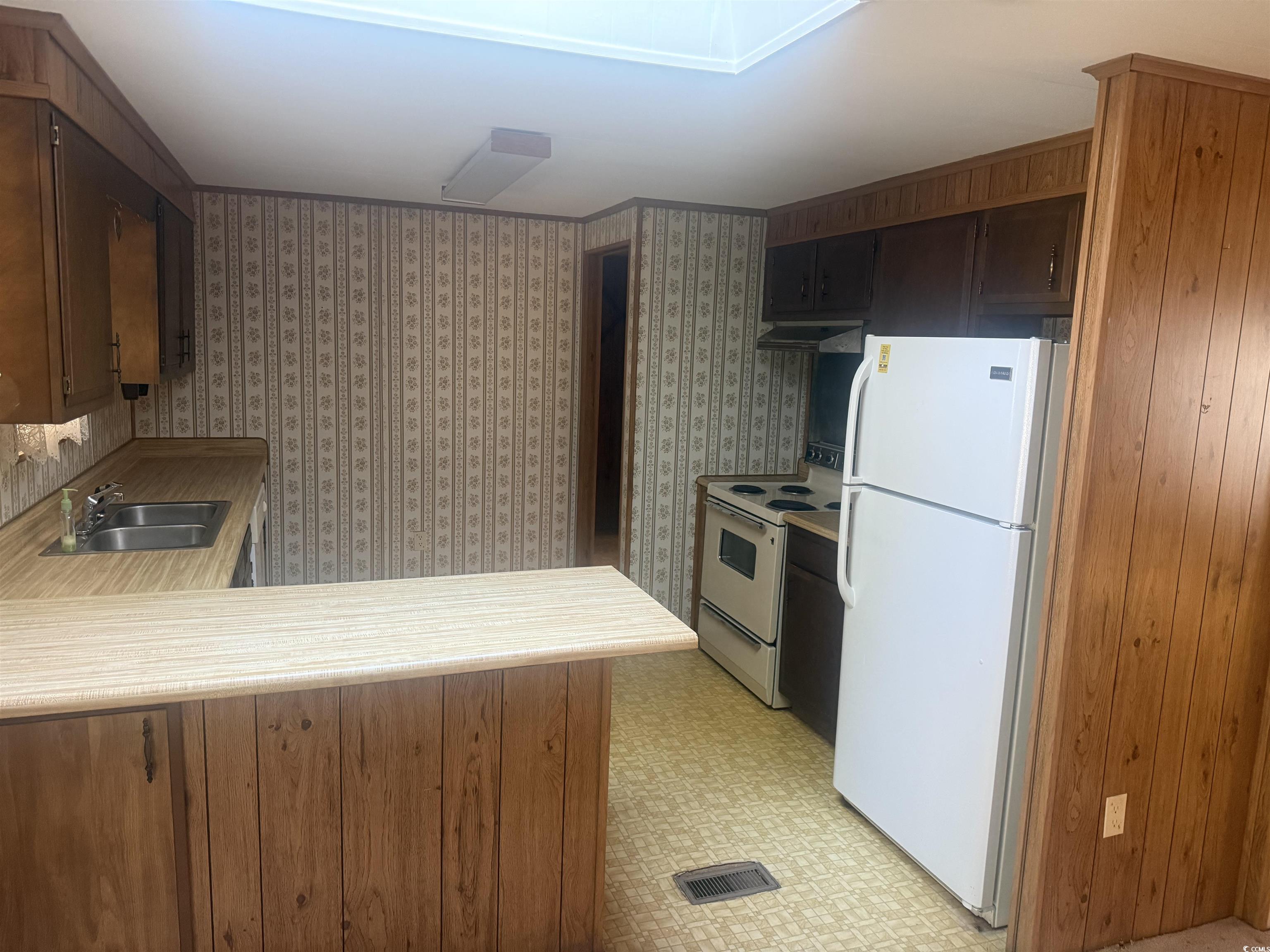 712 Raleigh Trail Murrells Inlet, SC 29576 - Photo 15 of 32 Kitchen with white appliances, light countertops, ventilation hood, dark brown cabinets, and light flooring