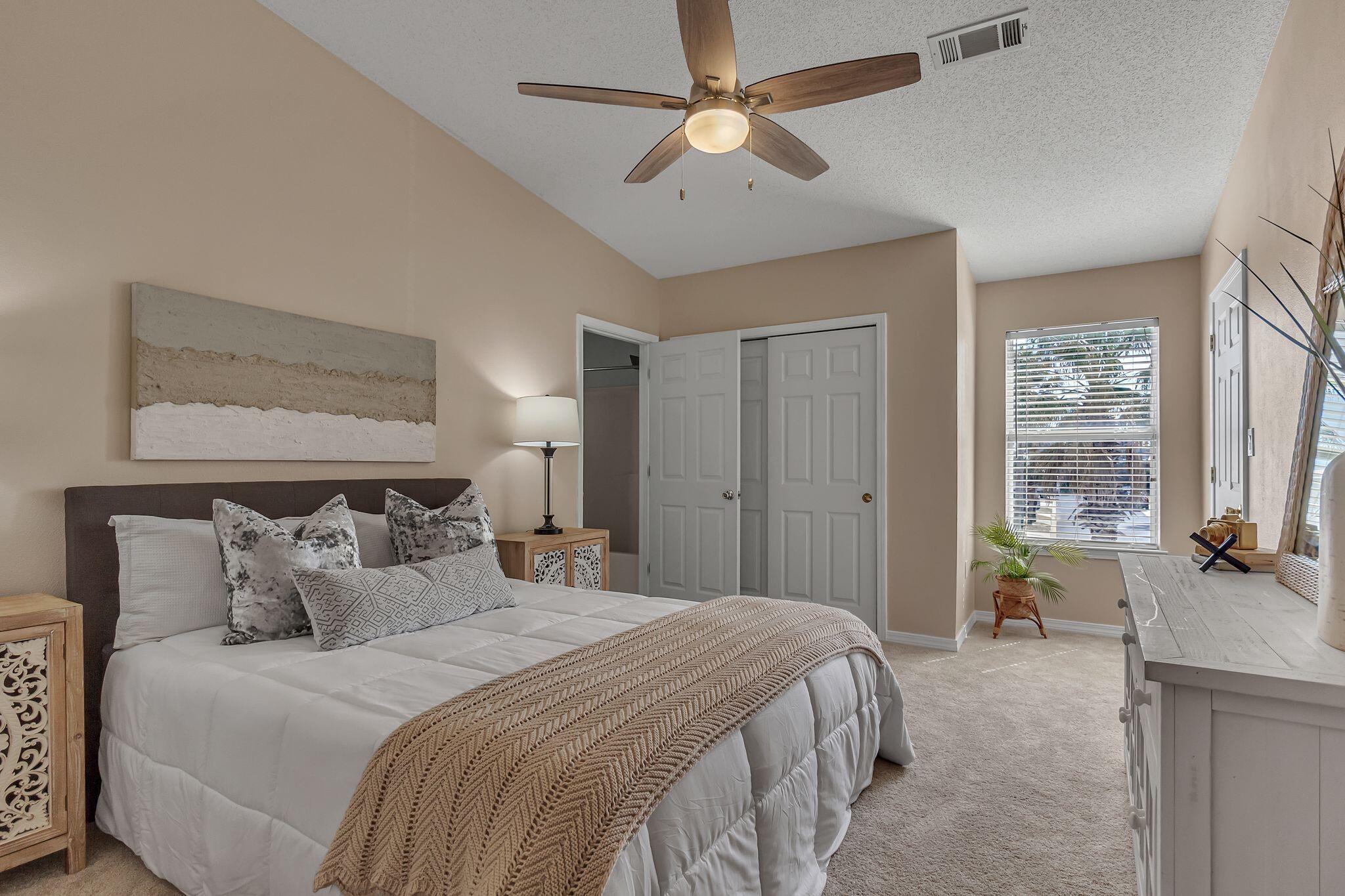 150 Bent Arrow Drive, Unit 51 Destin, FL 32541 - Photo 13 of 28 a bedroom with a bed ceiling fan and a large window