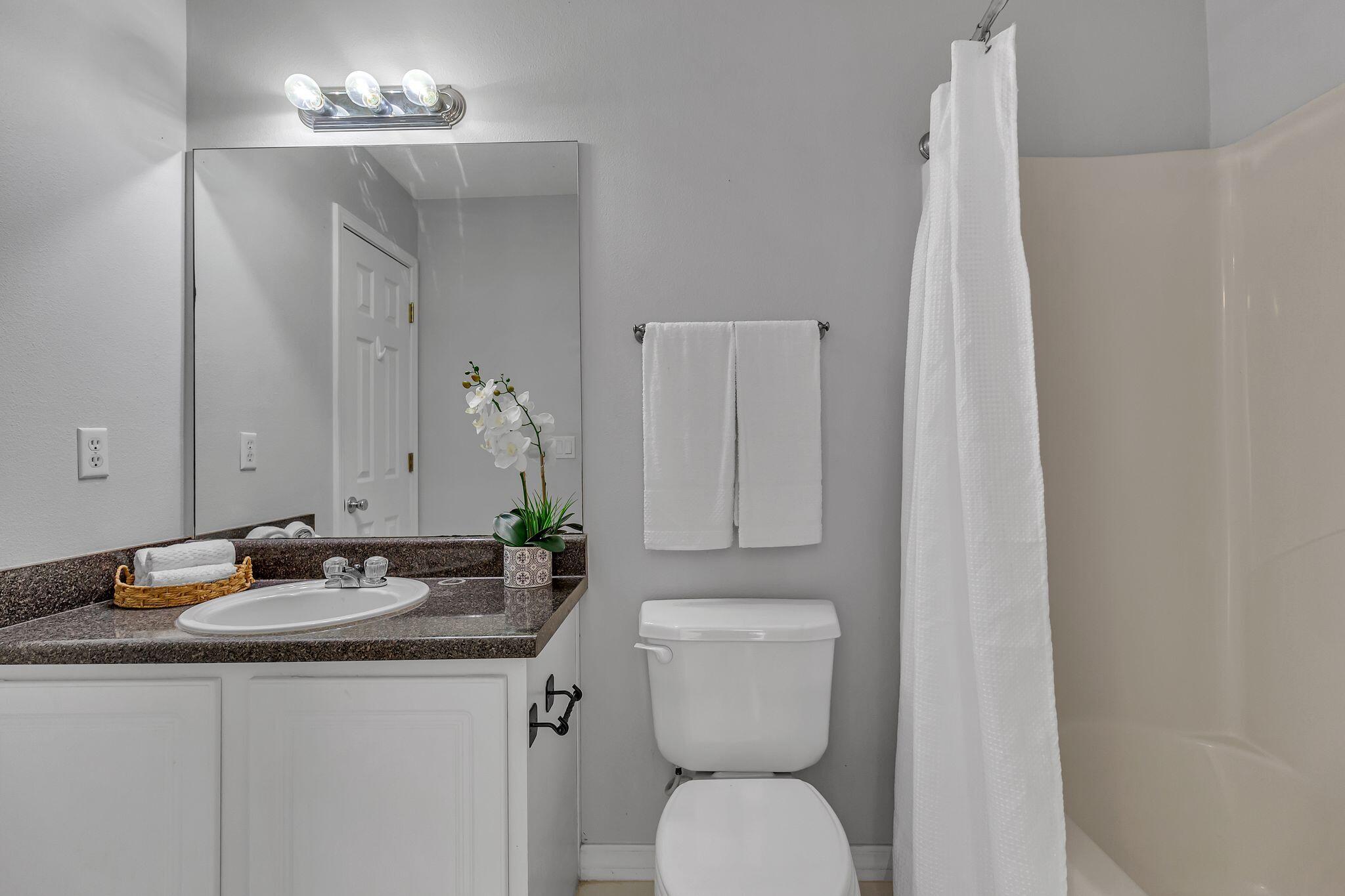 150 Bent Arrow Drive, Unit 51 Destin, FL 32541 - Photo 16 of 28 a bathroom with a granite countertop sink toilet and a mirror