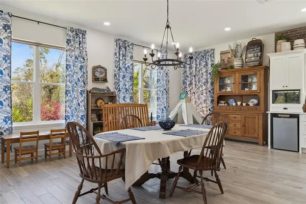 a kitchen with stainless steel appliances kitchen island granite countertop a table chairs and a refrigerator