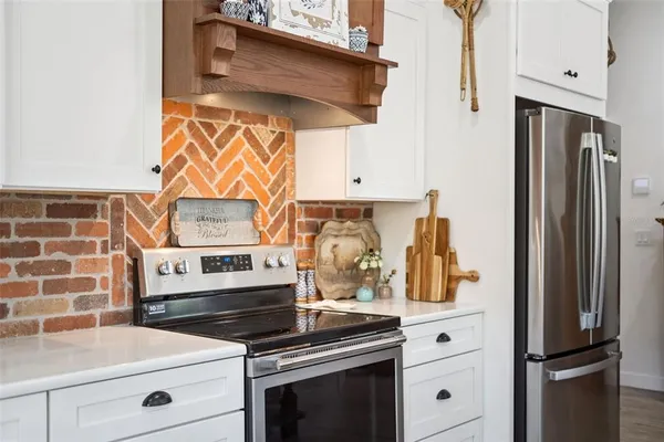 a kitchen with stainless steel appliances kitchen island granite countertop a sink refrigerator and cabinets