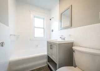 a bathroom with a granite countertop toilet a sink and bathtub