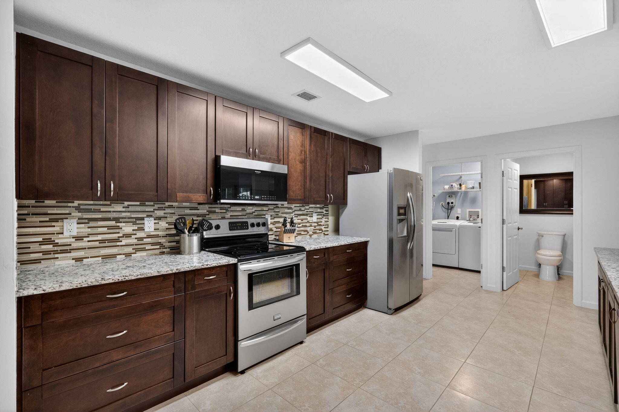 17391 Alexander Run Jupiter, FL 33478 - Photo 10 of 55 a kitchen with refrigerator cabinets and microwave