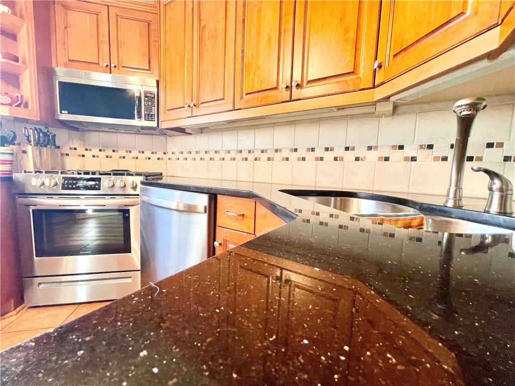48 Perry View Avenue Pittsburgh, PA 15214 - Photo 8 of 24 a kitchen with stainless steel appliances granite countertop a sink and a stove