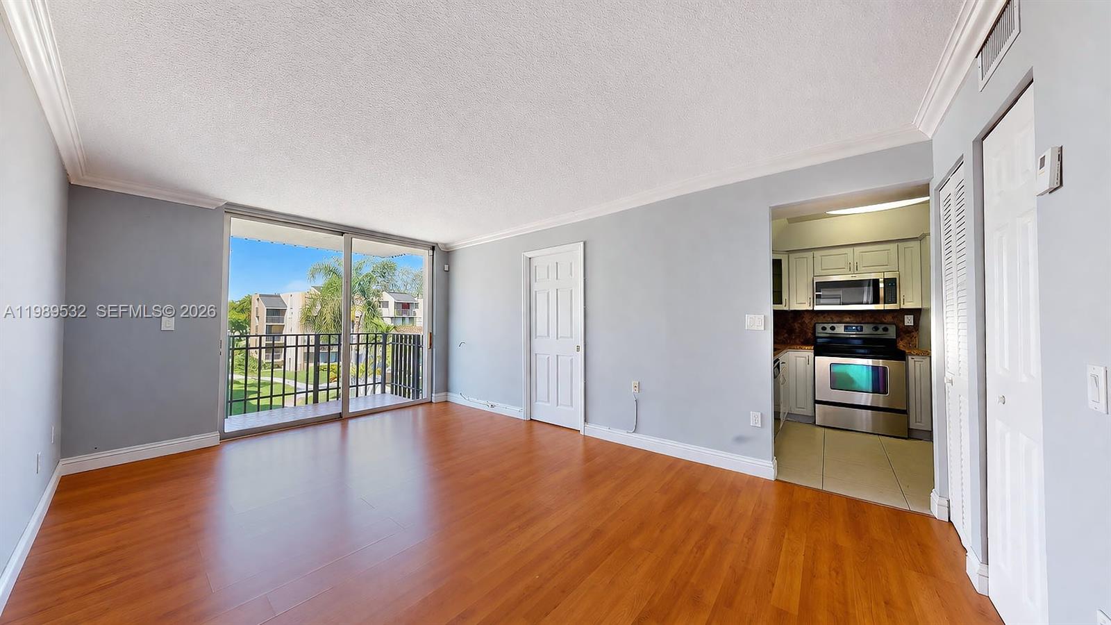 3581 Southwest 117th Avenue, Unit 5308 Miami, FL 33165 - Photo 11 of 38 a view of an empty room with wooden floor and a window