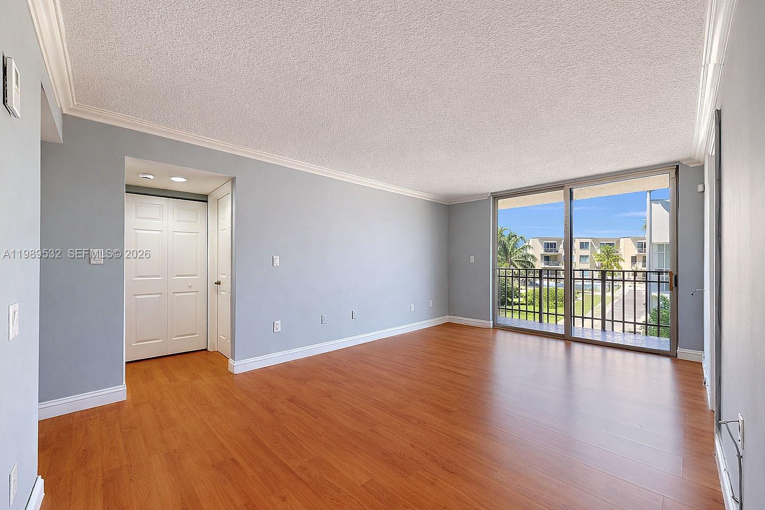 3581 Southwest 117th Avenue, Unit 5308 Miami, FL 33165 - Photo 12 of 38 a view of an empty room with wooden floor and a window