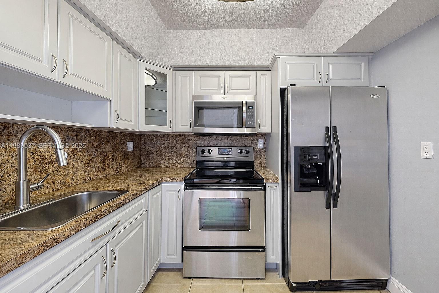 3581 Southwest 117th Avenue, Unit 5308 Miami, FL 33165 - Photo 18 of 38 a kitchen with a stove microwave and refrigerator