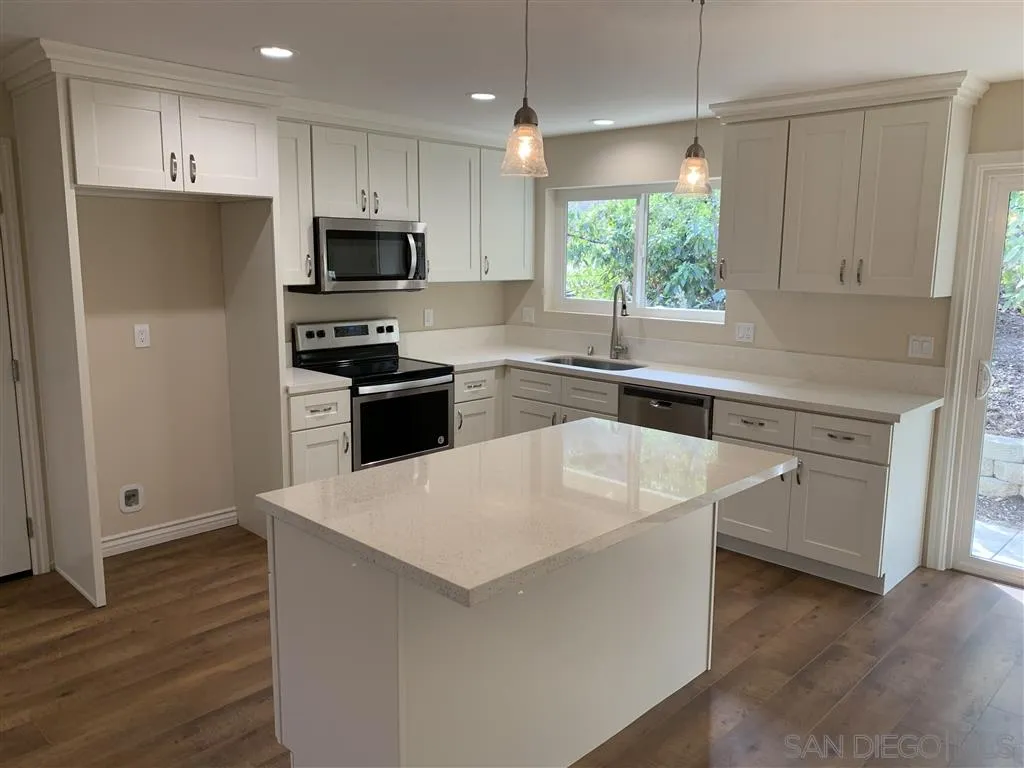 9046 Westhill Road Lakeside, CA 92040 - Photo 3 of 11 a kitchen with white cabinets and stainless steel appliances