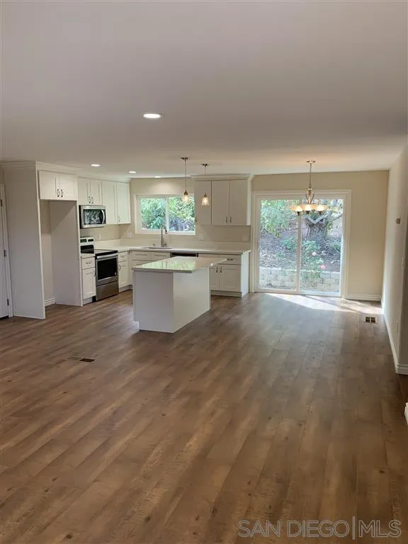 9046 Westhill Road Lakeside, CA 92040 - Photo 4 of 11 a open kitchen with white cabinets and wooden floor