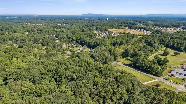 an aerial view of residential houses with outdoor space and trees