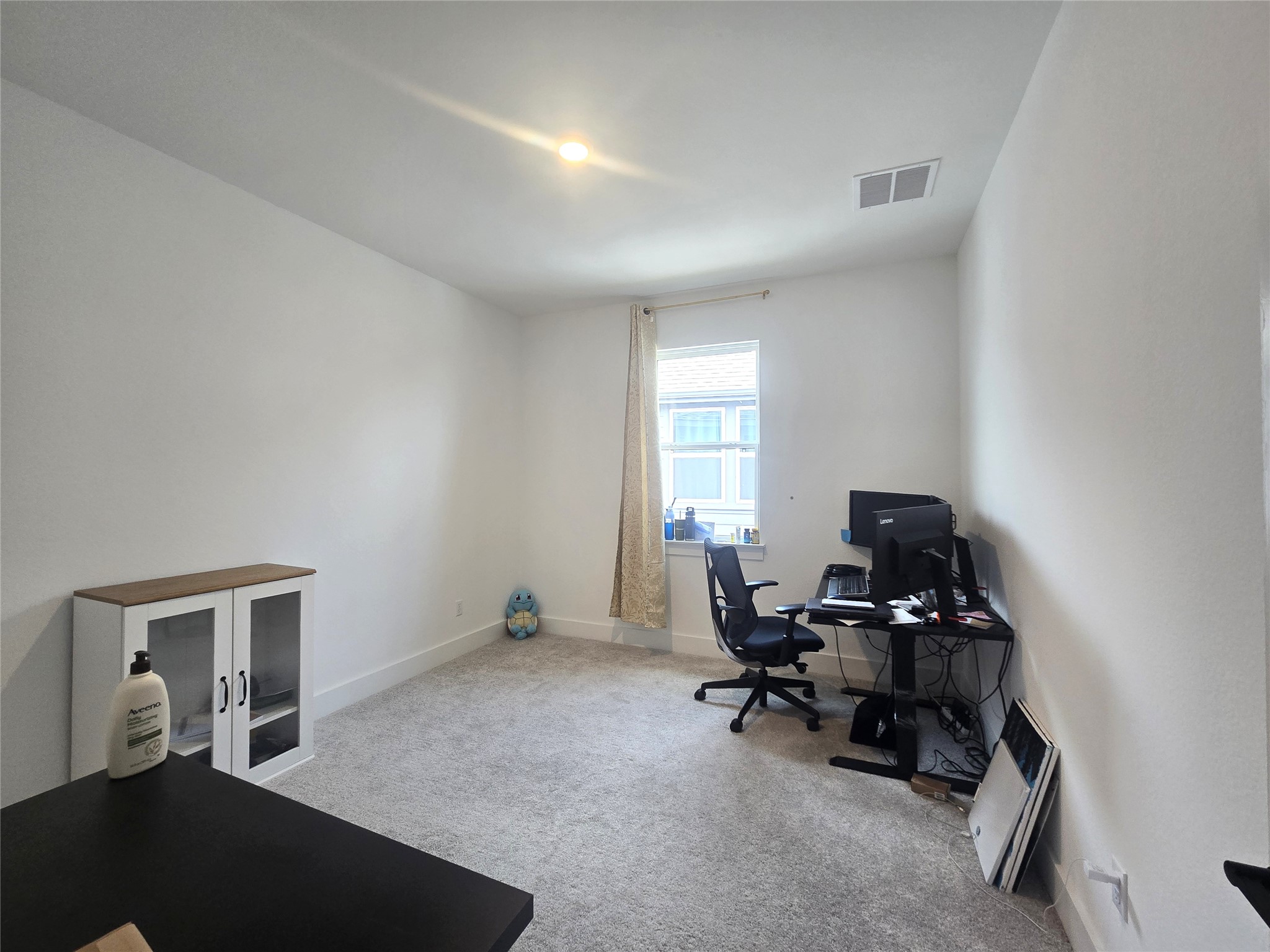 124 Ribera Drive Liberty Hill, TX 78642 - Photo 21 of 40 A versatile space, perfect for a home office or cozy bedroom, features ample natural light and plush carpeting.