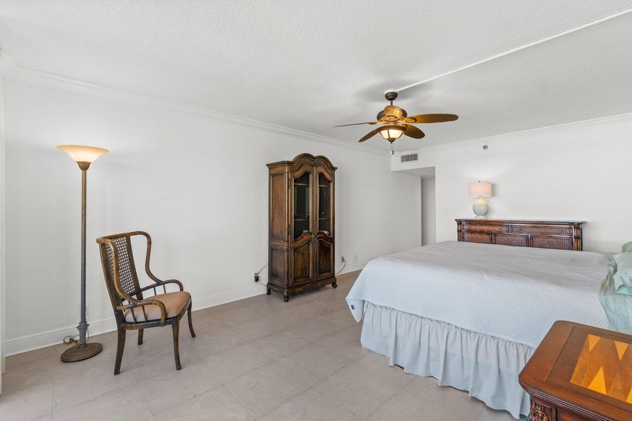 1401 South Ocean Boulevard, Unit 3090 Boca Raton, FL 33432 - Photo 12 of 46 a bedroom with a bed and a chair