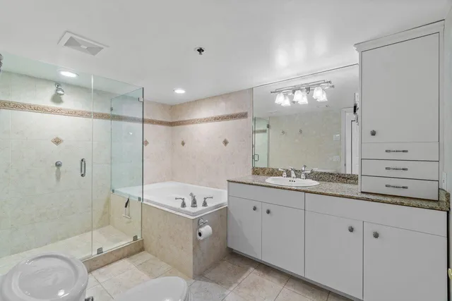 a spacious bathroom with a granite countertop sink mirror and shower