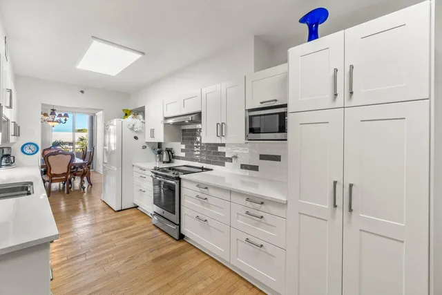 a kitchen with white cabinets and stainless steel appliances