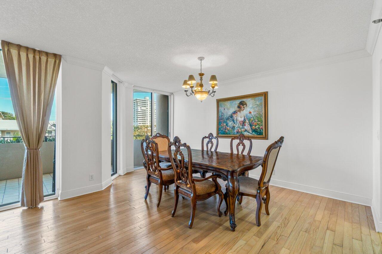 1401 South Ocean Boulevard, Unit 3090 Boca Raton, FL 33432 - Photo 9 of 46 a view of a dining room with furniture wooden floor and chandelier